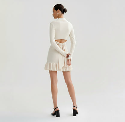 Woman wearing a Ivory dress with long sleeves on a plain background