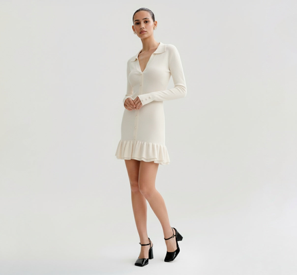 Woman wearing a Ivory dress with long sleeves on a plain background