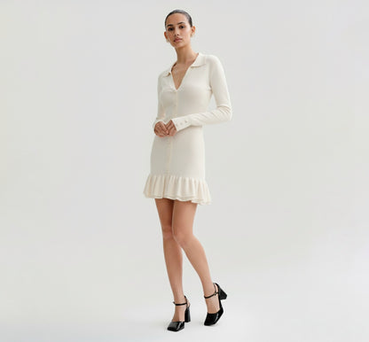 Woman wearing a Ivory dress with long sleeves on a plain background