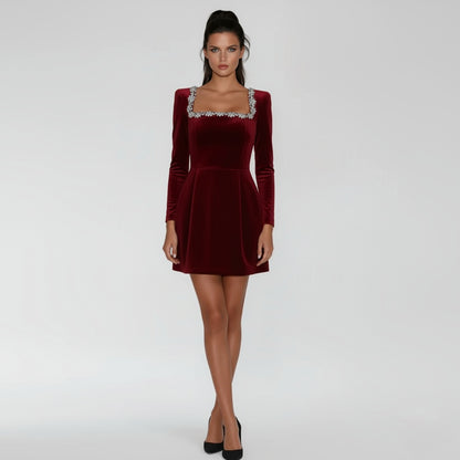 Woman wearing a Claret velvet dress with long sleeves on a white background