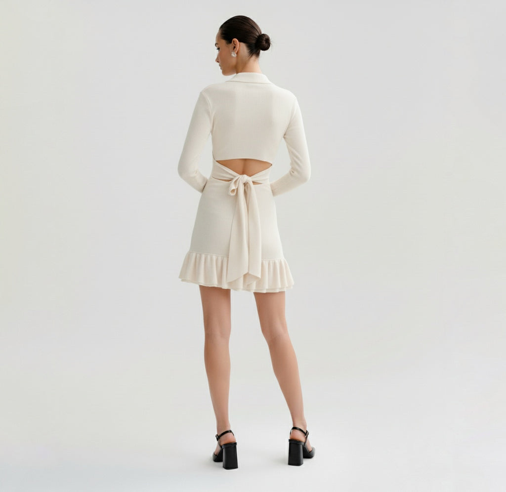 Woman wearing a Ivory dress with long sleeves on a plain background