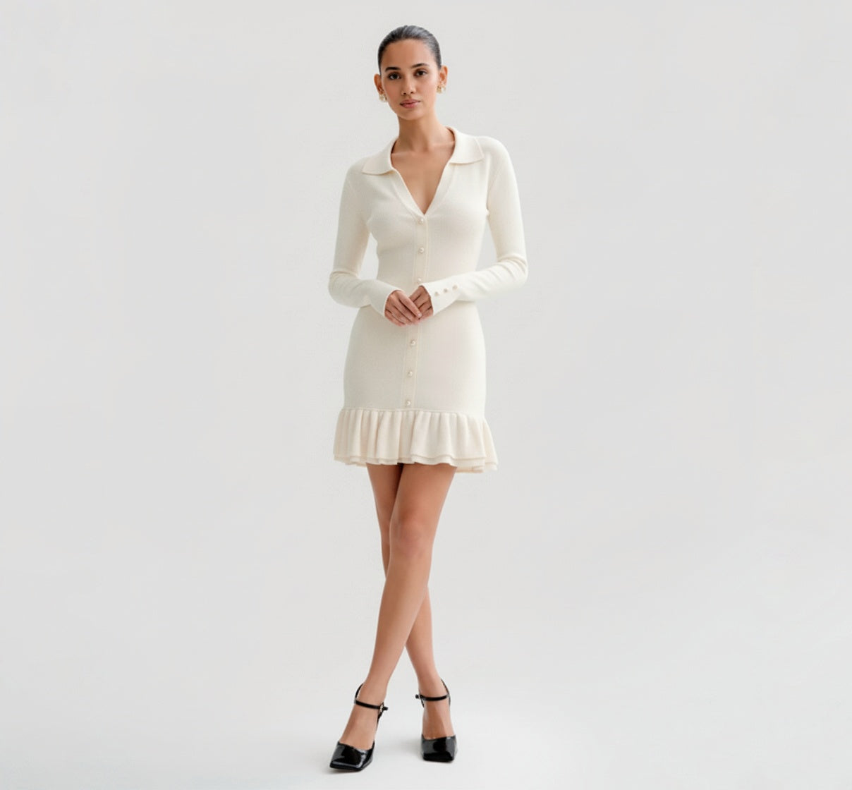 Woman wearing a Ivory dress with long sleeves on a plain background