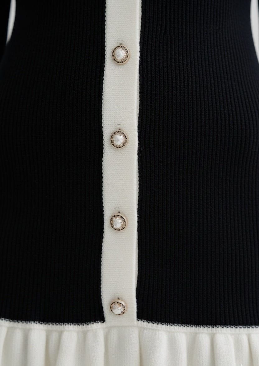 Close-up of a Black and white cardigan with decorative buttons.